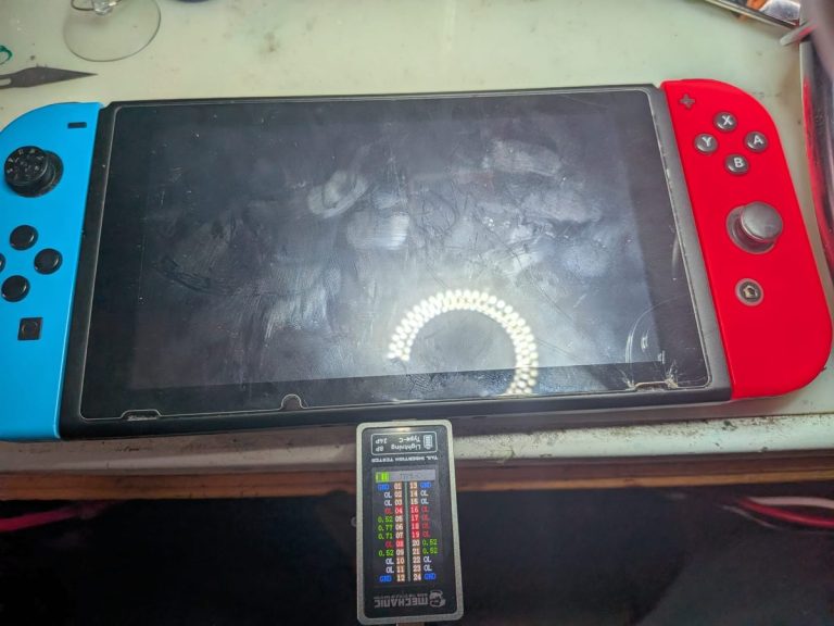 Nintendo Switch reparada cargando con un medidor USB-C en el taller de CET Reparaciones